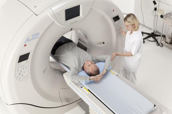 https://daic.s3.amazonaws.com/s3fs-public/styles/content_feed_large_new/public/field/image/CT%20scan%20with%20patient%20and%20tech_from%20RSNA%202012%20PR%20Toshiba_Aquilion%20ONE%20ViSION%204.jpg